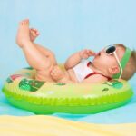 photo d'un bébé dans une bouée qui profite du soleil avec des lunettes