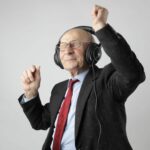 photo d'un monsieur âgé qui danse avec un casque audio sur les oreilles et les yeux fermés.