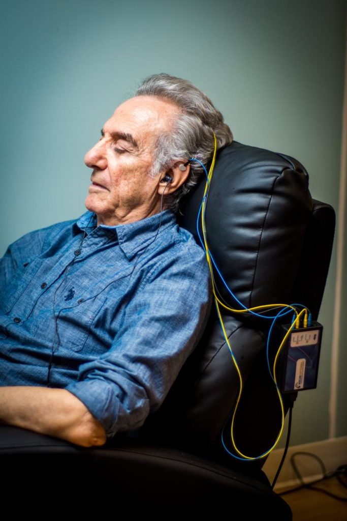 Un senior est en séance de neurofeedback. Il est installé dans un fauteuil confortable.