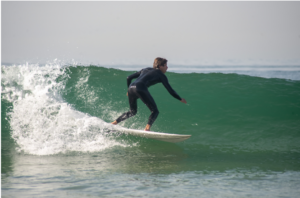 Photo d'un homme qui surfe sur une vague